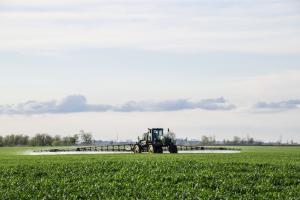 Tractor applying pesticide in field
