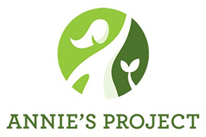 Annie's Project logo, white silhouette of woman and plant against green circle. 