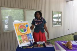 staff member at a booth with nutrition education information
