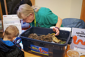 Master Gardener showing boy a worm bin