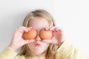 girl holding eggs in front of her face