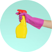 gloved hand holding plastic spray bottle
