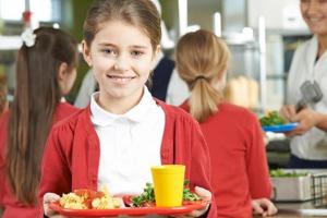 Elementary student holding school lunch tray