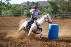 Girl barrel racing on horse