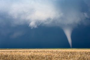 Photo of tornado touching down on brown field