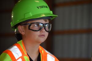 little boy in hard hat, safety glasses and safety vest