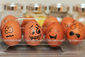 Brown eggs with different faces drawn on them representing various emotions.