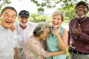 Group of happy older adults laughing outside in a park