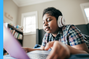 a boy with headphones on a laptop