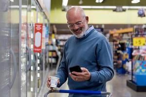 Man in grocery store looking at phone 