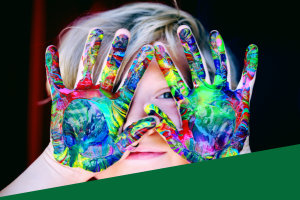 child with paint covered hands and the word inspire