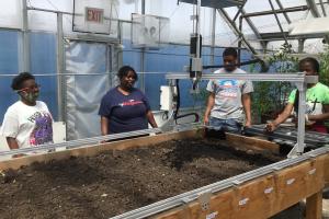 4 youth with robot planting seeds