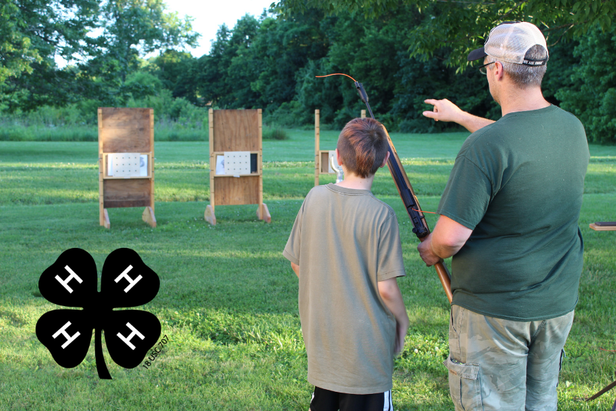 Child and man standing by shooting target