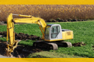 backhoe digging a trench in a field