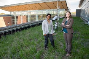 two people standing on U of I campus building demonstrating green roof