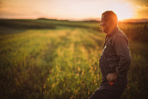 farmer thinking while walking in soybean field