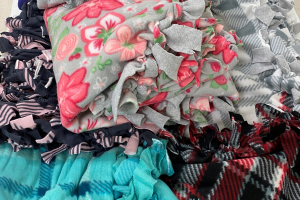 Various colors and patterns of fleece material made into tie-knot blankets