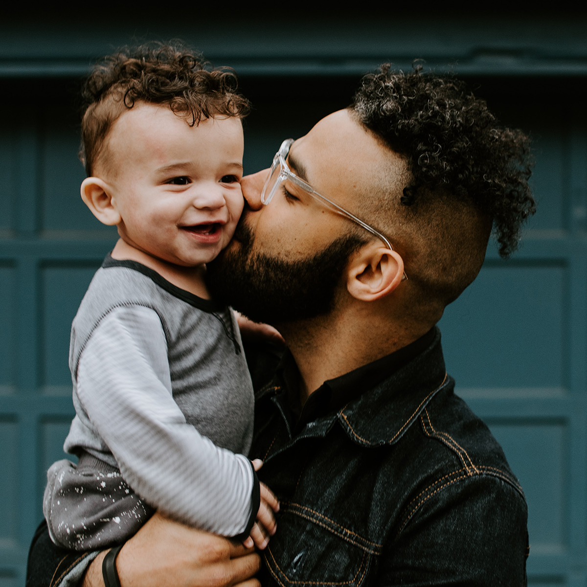 man kissing young baby