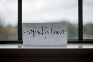 Mindfulness written on a piece of paper propped up in a window
