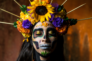 Hispanic woman wearing flower crown and dia de los muertos makeup