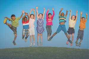 smiling kids jumping with hands in the air
