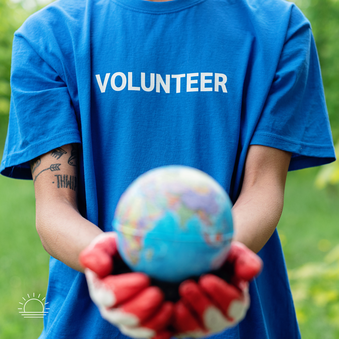 person in volunteer shirt holding globe