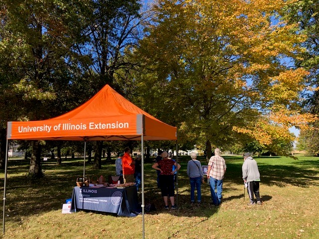 People under a tent outside talking to others