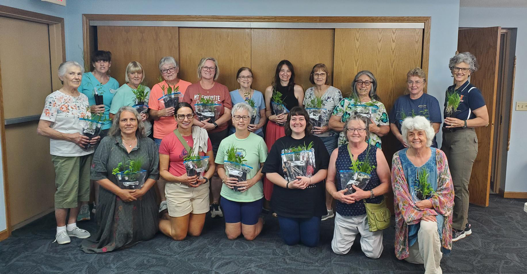 People pose for a photo with plants