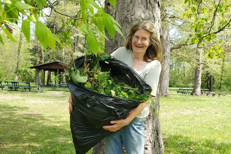 A woman holding a bag of plants