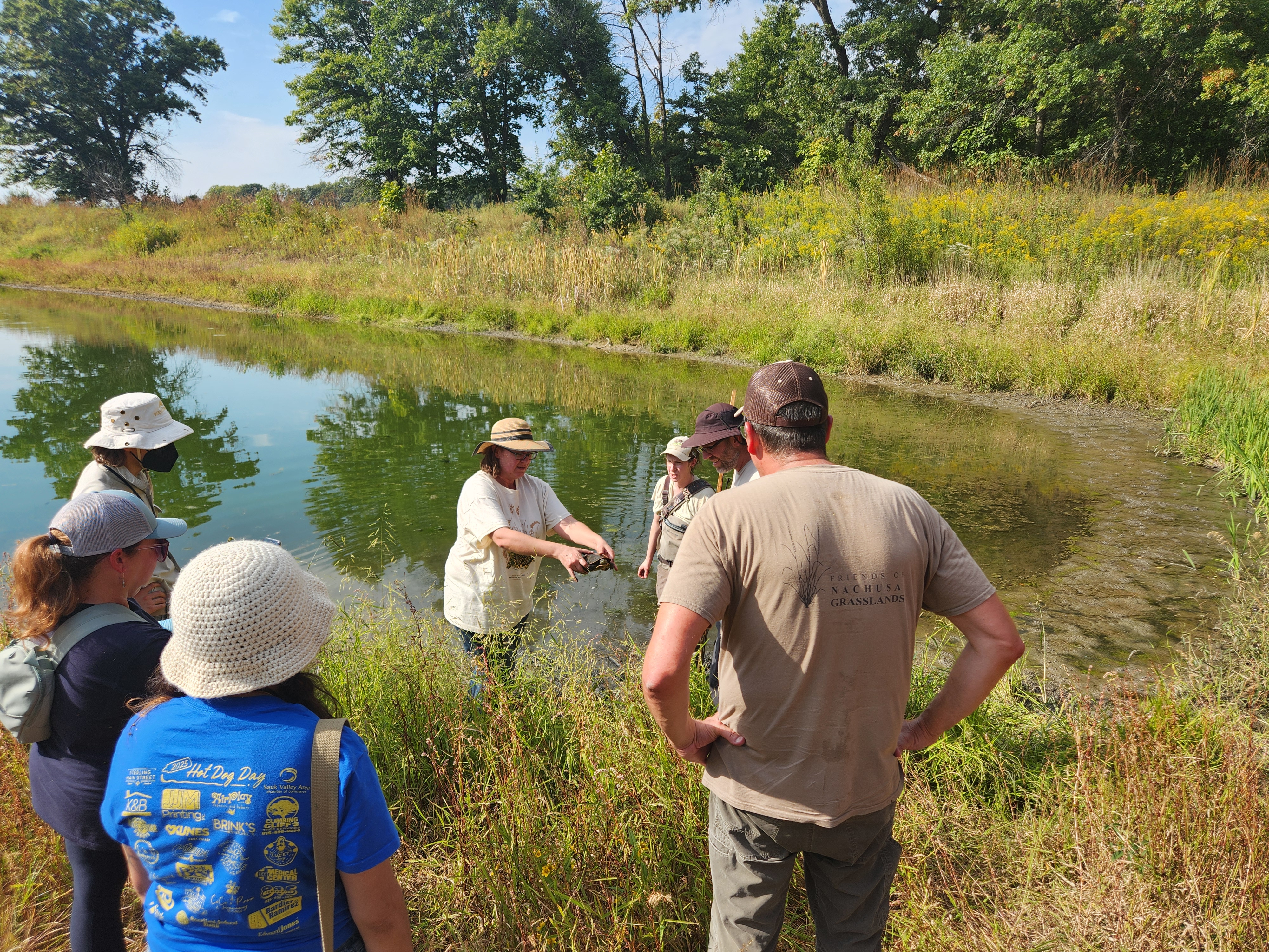 a Woman at a pond with a group of people