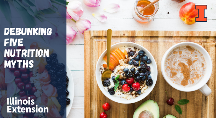 Overhead view of a bowl of oatmeal with fruit, a cup of coffee, and avocado on a cutting board.