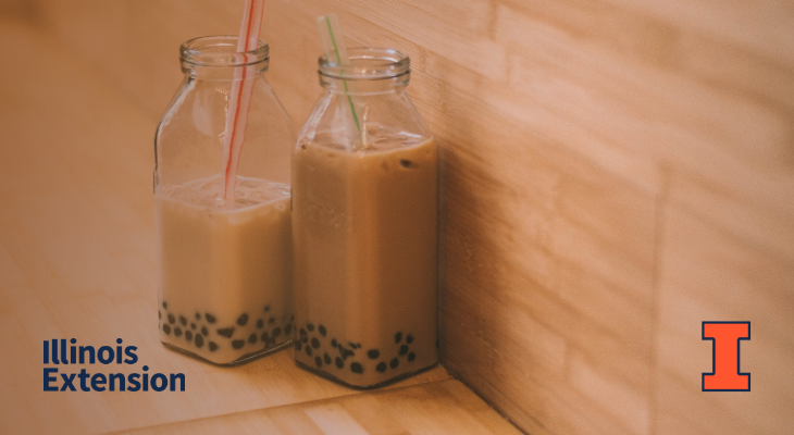 Two glass bottles with a tan colored tea and black tapioca pearls at the bottom on a table. Contains orange I block logo and Illinois Extension wordmark.