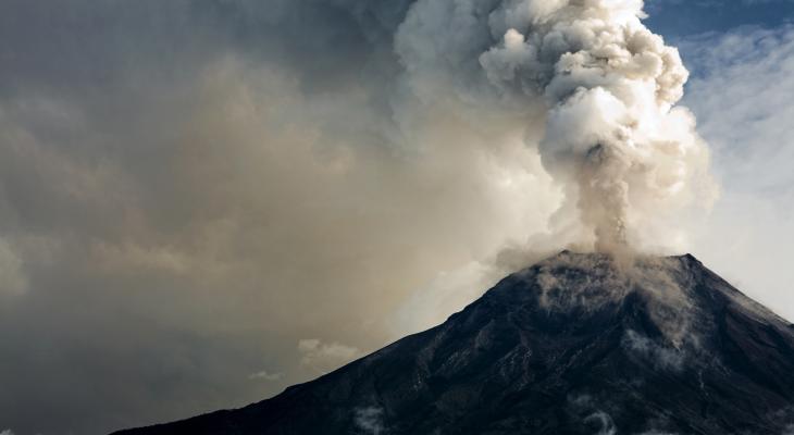 gray volcano erupting plume of smoke and ash