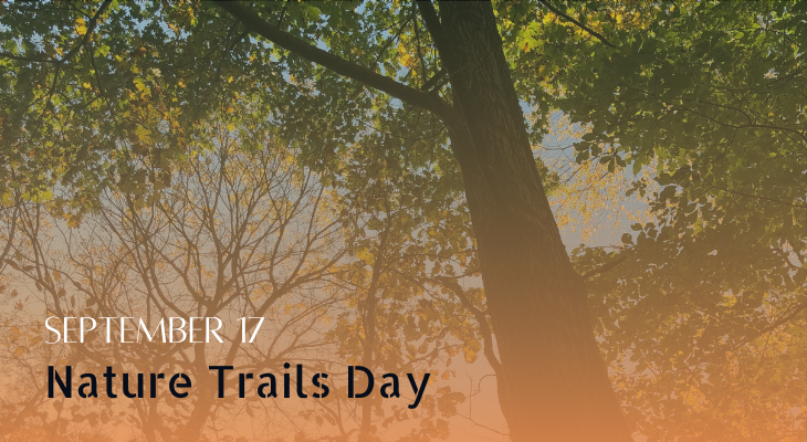 An orange filter fade with the words September 17 Nature Trails Day overlays a view up into the tree canopy.