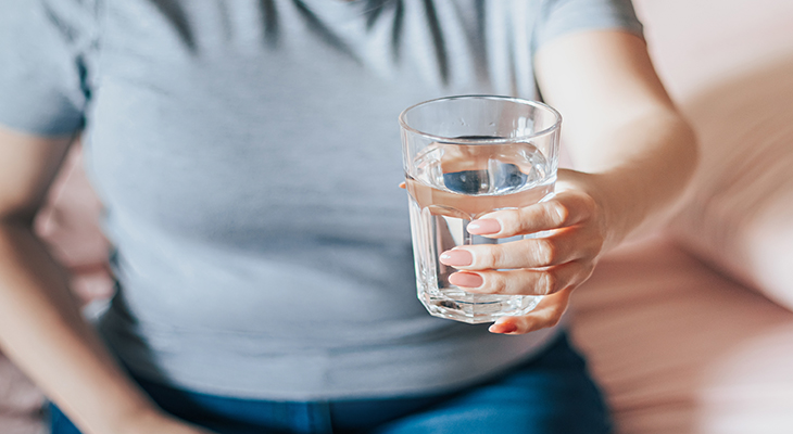 Person holding a glass filled with water
