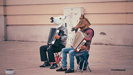 people with horse head costume on playing instrument