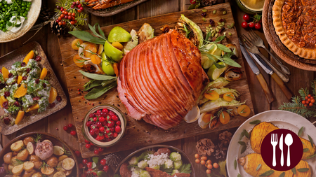 A spiral ham in the middle of a table and various side dishes placed around the table.