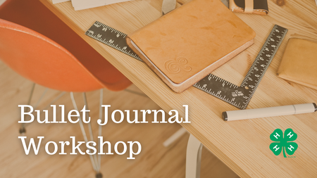 Desk with clutter stating Bullet Journal Workshop and emblem