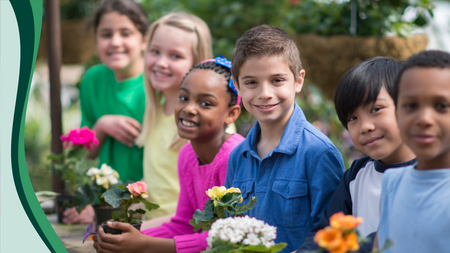 smiling children holding plants and flowers