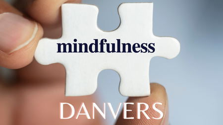 White puzzle piece with the word mindfulness printed. Danvers is printed below the puzzle