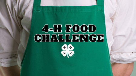 A chef wearing a green apron with the text "4-H Food Challenge" on the middle of the apron with a white 4-H clover underneath the text.