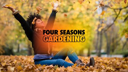 A person smiling while celebrating being outdoors by throwing fall leaves into the air.