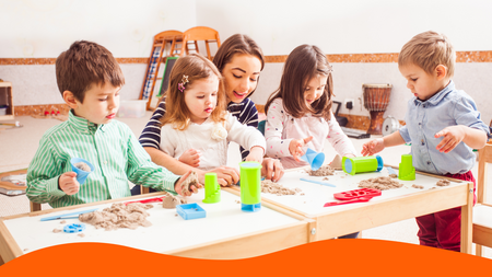 A teacher and kids playing with kinetic sand on a table.