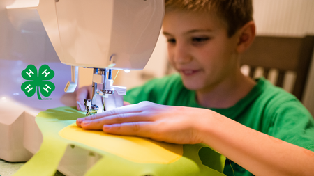 boy in green shirt using a sewing machine