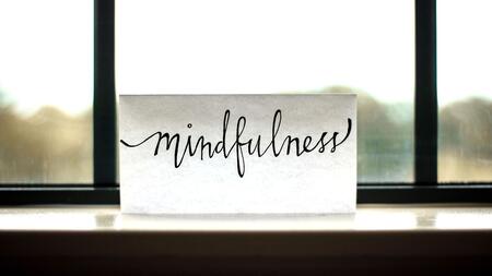 "Mindfulness" written on a card sitting on a shelf in front of a window