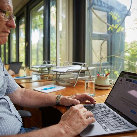 A person sitting and working from a laptop computer.