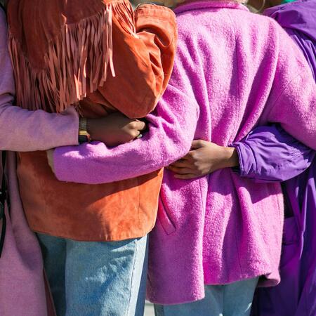 four people holding each other at the waist during the daytime