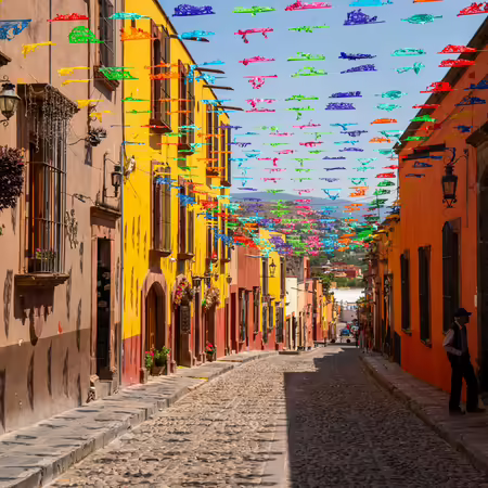 Cobblestone street with colorful banners hanging over head