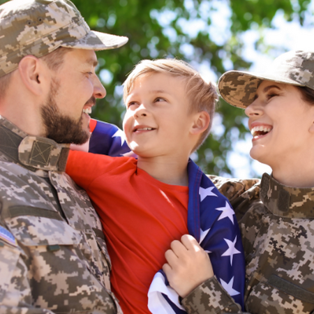 military family hugging with flag