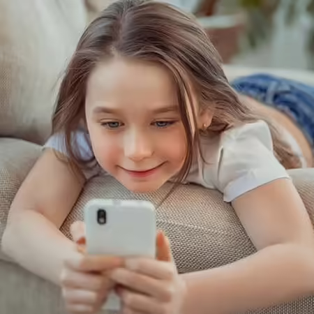 Young girl playing on a smartphone.